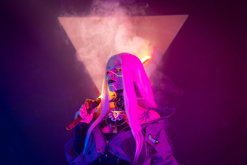 Pink-haired cyberpunk portrait with a neon face wire and a glowing triangle in the smoke