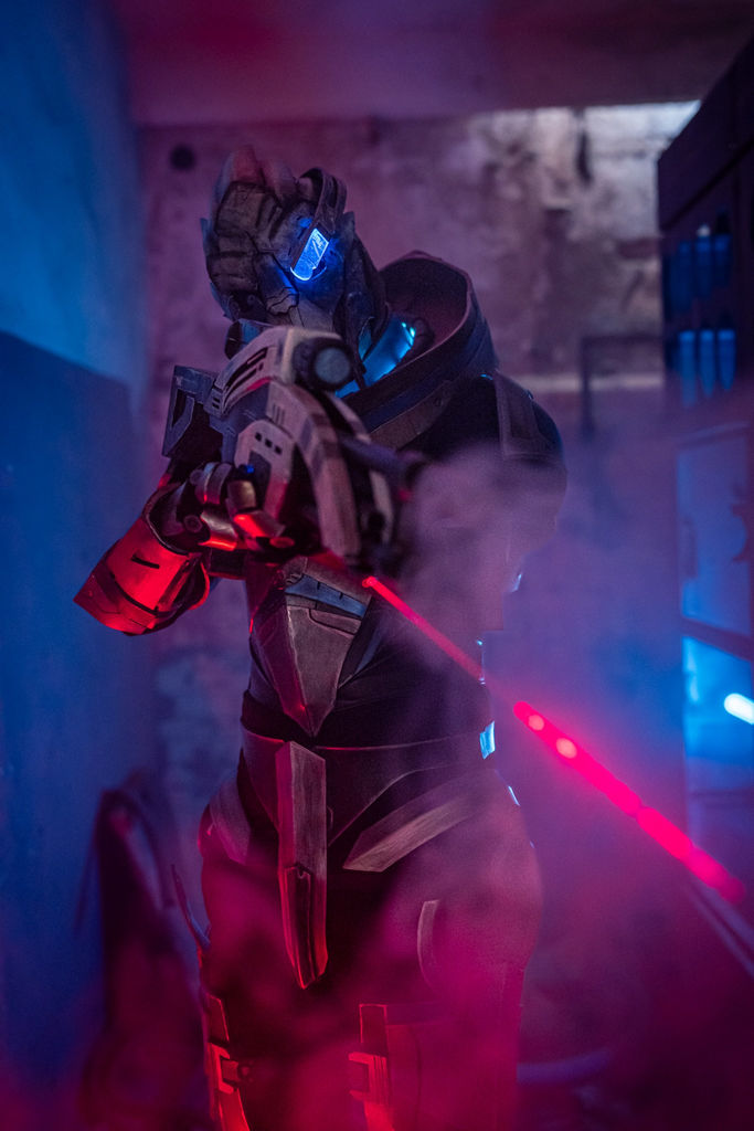 Garrus Vakarian from Mass Effect in full armor, aiming through blue and red fog