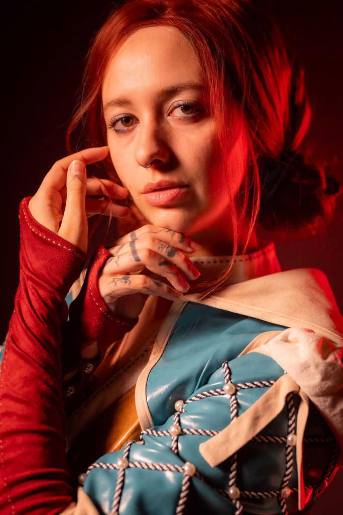 Close-up portrait of Triss Merigold from The Witcher in warm red light